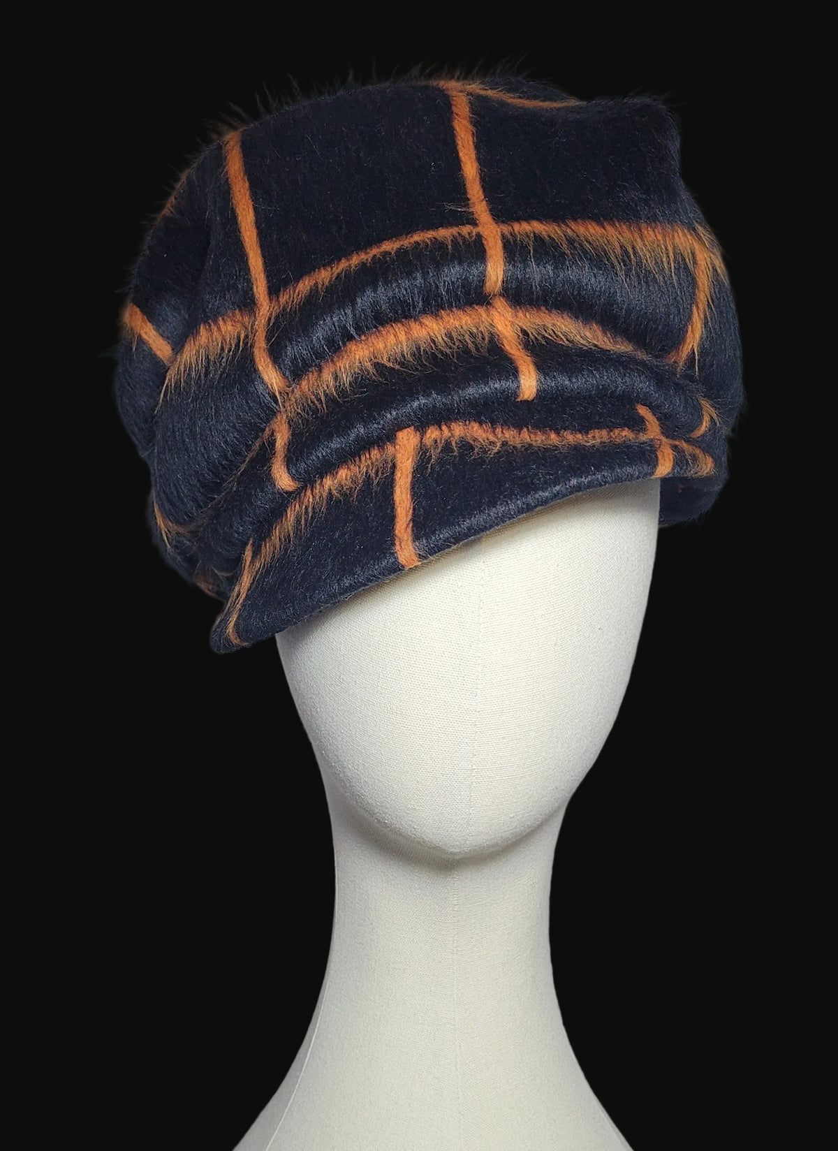 Faux fur cap black & orange windowpane plaid pattern, displayed on a white mannequin head against a black background.