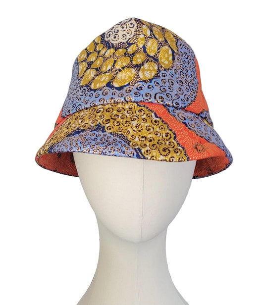 A bucket hat with a vibrant multicolor African wax print pattern, orange, blue and gold
