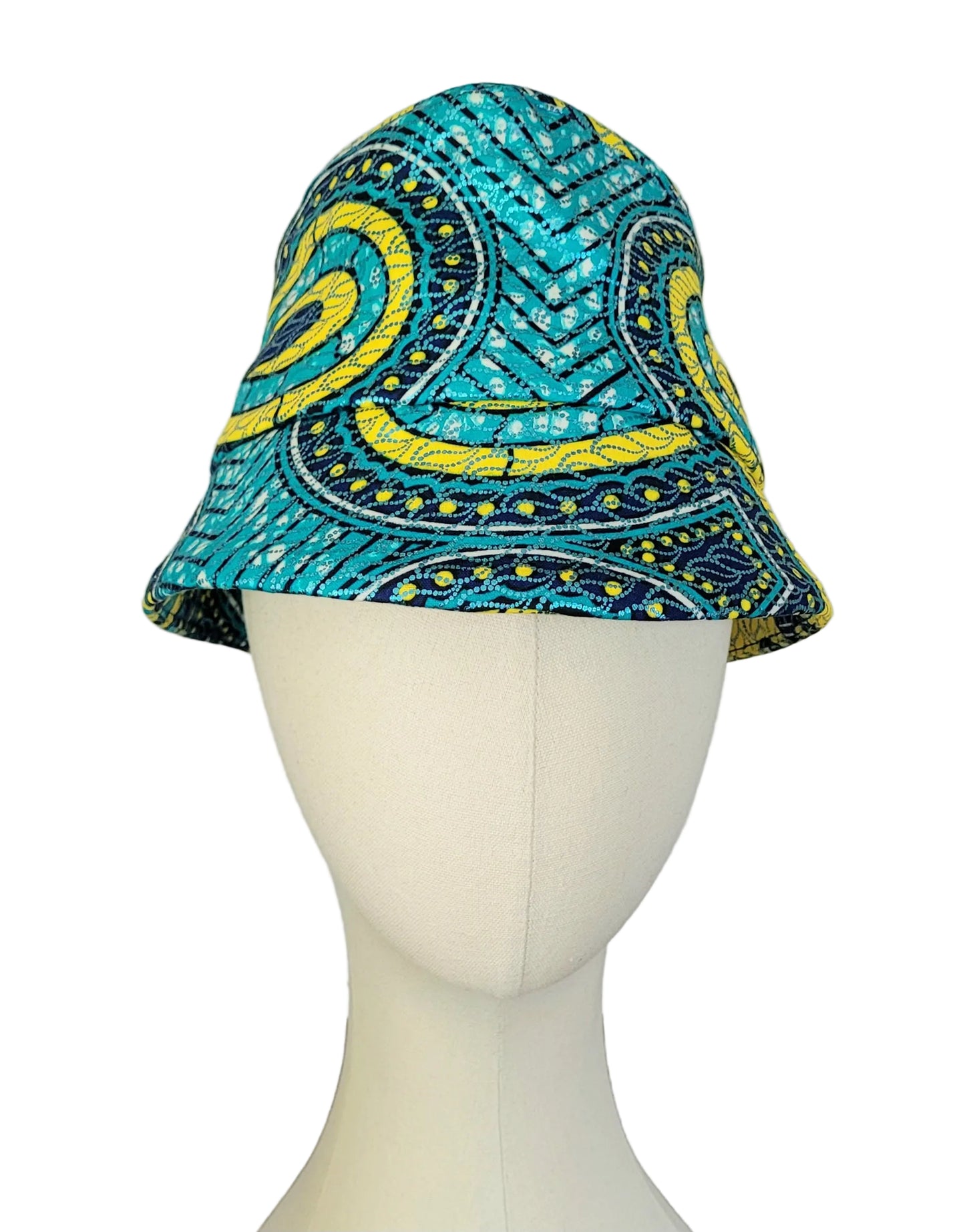 A bucket hat with a vibrant turquoise, yellow, and dark blue paisley pattern, displayed on a white mannequin head against a plain white background.