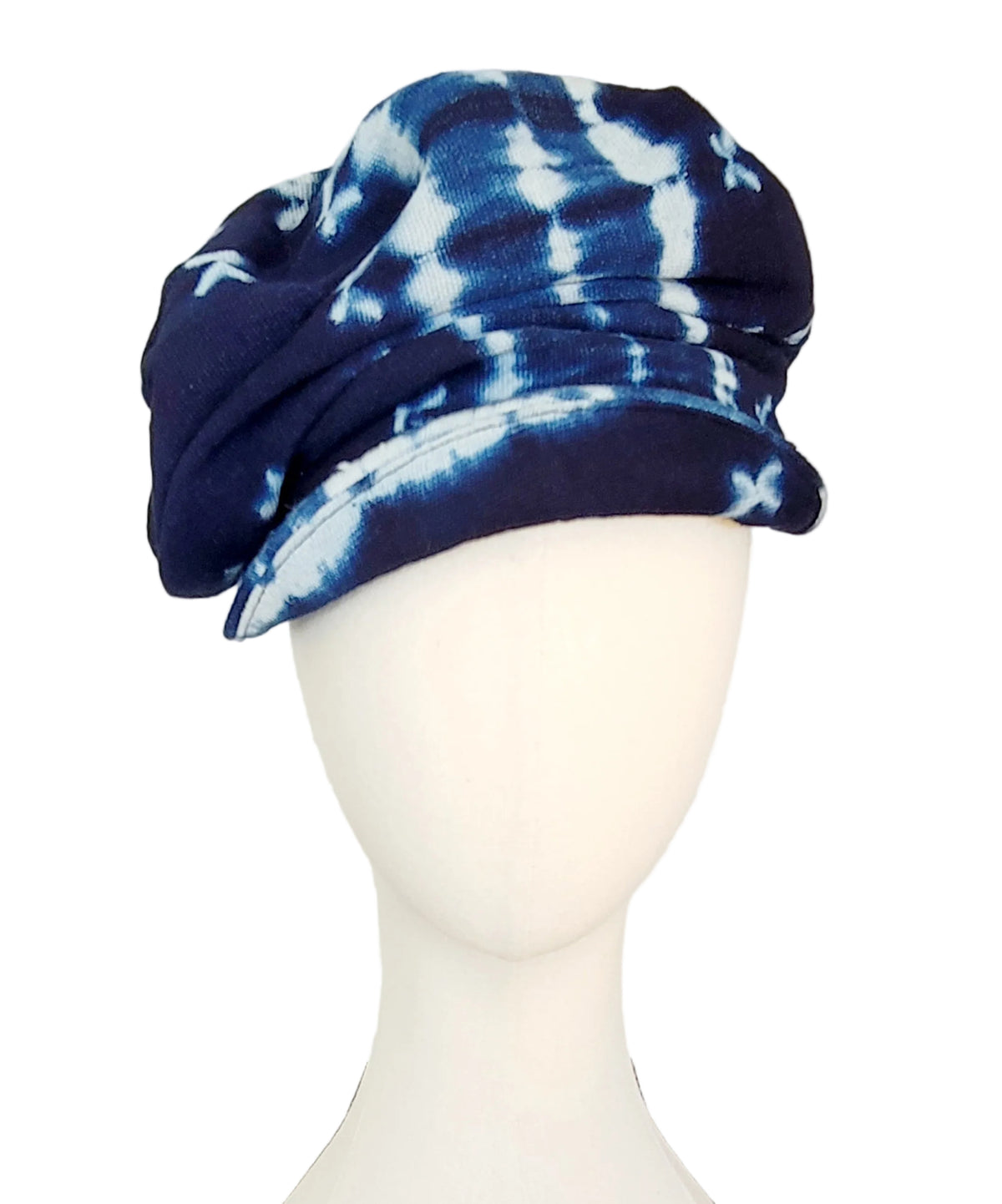 A navy blue and white tie-dye cap displayed on a white mannequin head against a plain white background.