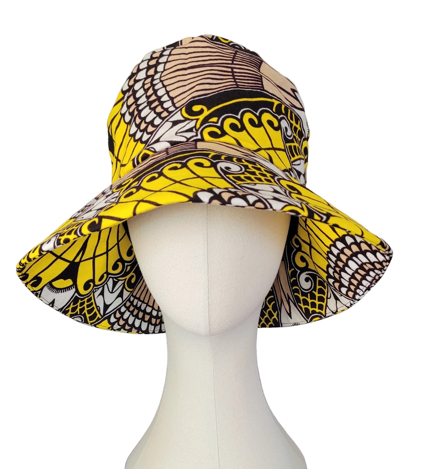 A wide-brim sun hat with a bold yellow, black, and brown African wax print pattern, displayed on a white mannequin head.